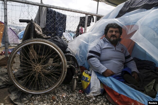 A person with a physical disability in a refugee camp sitted near a tent and his wheel chair